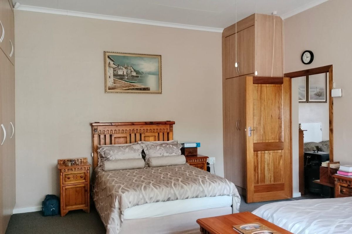 A bedroom featuring built-in wooden cupboards and a solid timber door, providing functional storage and classic interior finishes.