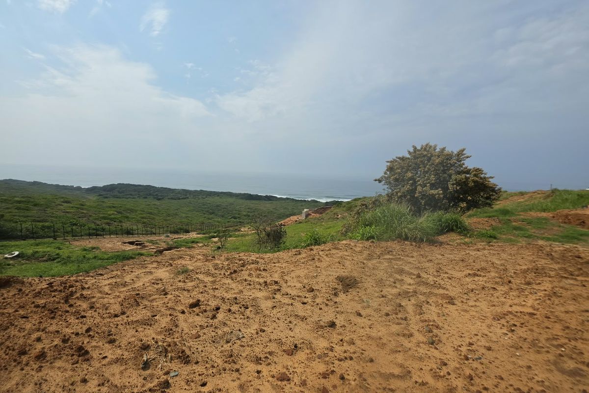 A scenic view overlooking a coastal landscape with natural vegetation and distant ocean horizon from the vacant residential land.
