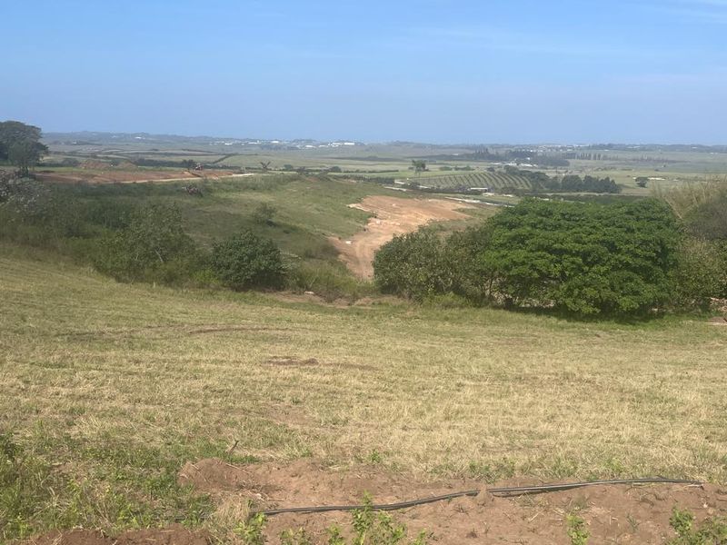 A wide-angle view of the vacant residential land, showcasing the natural landscape and surrounding terrain.
