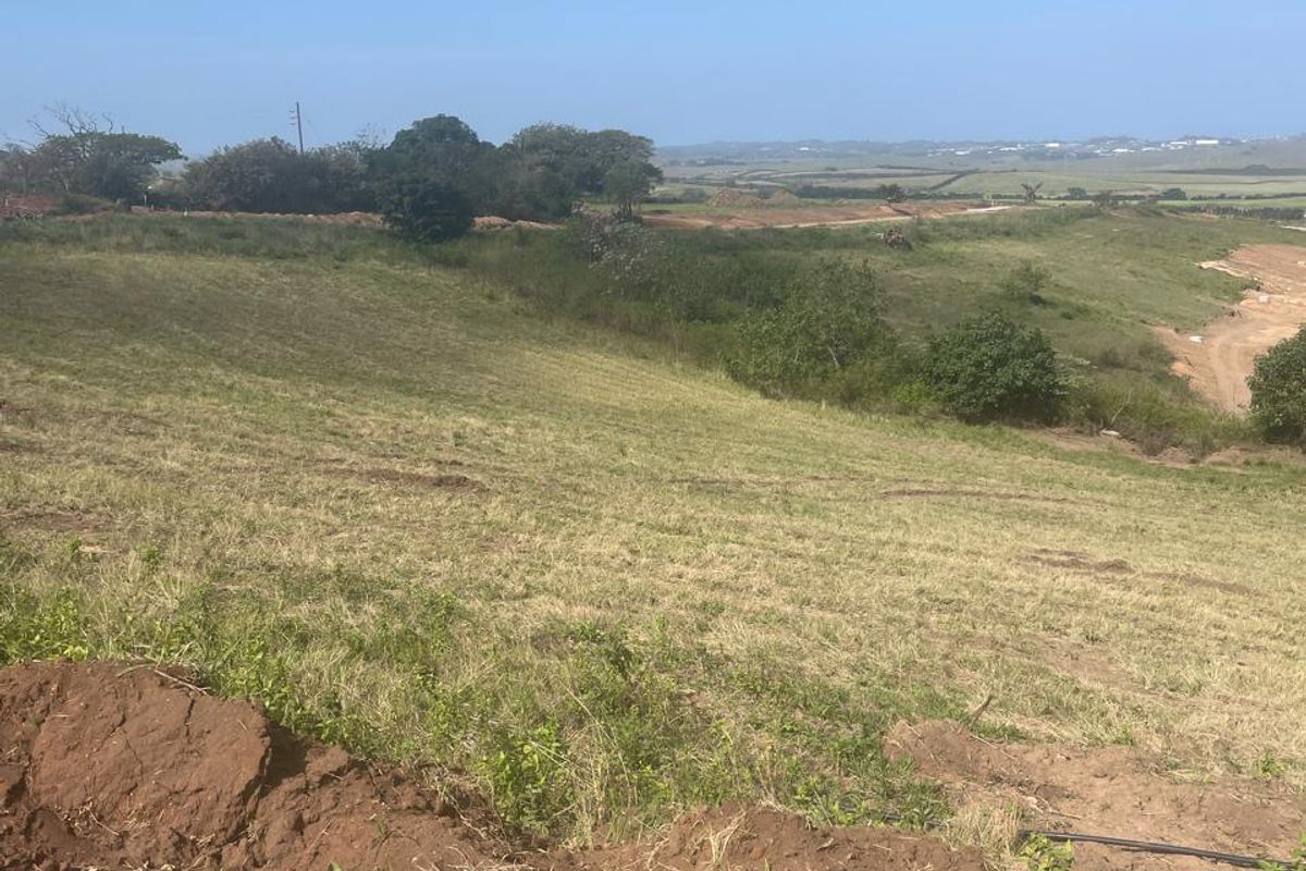 A wide-angle view of the vacant residential land, showcasing the natural sloped topography and surrounding landscape.