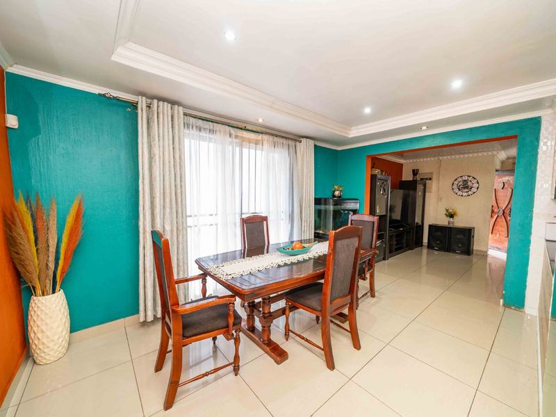 A dining room featuring tiled flooring, recessed downlighting, and a sliding glass door providing access to the exterior.