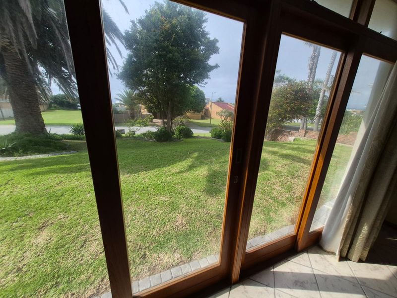 View from the interior through timber sliding doors looking out onto a well-maintained garden and street frontage.