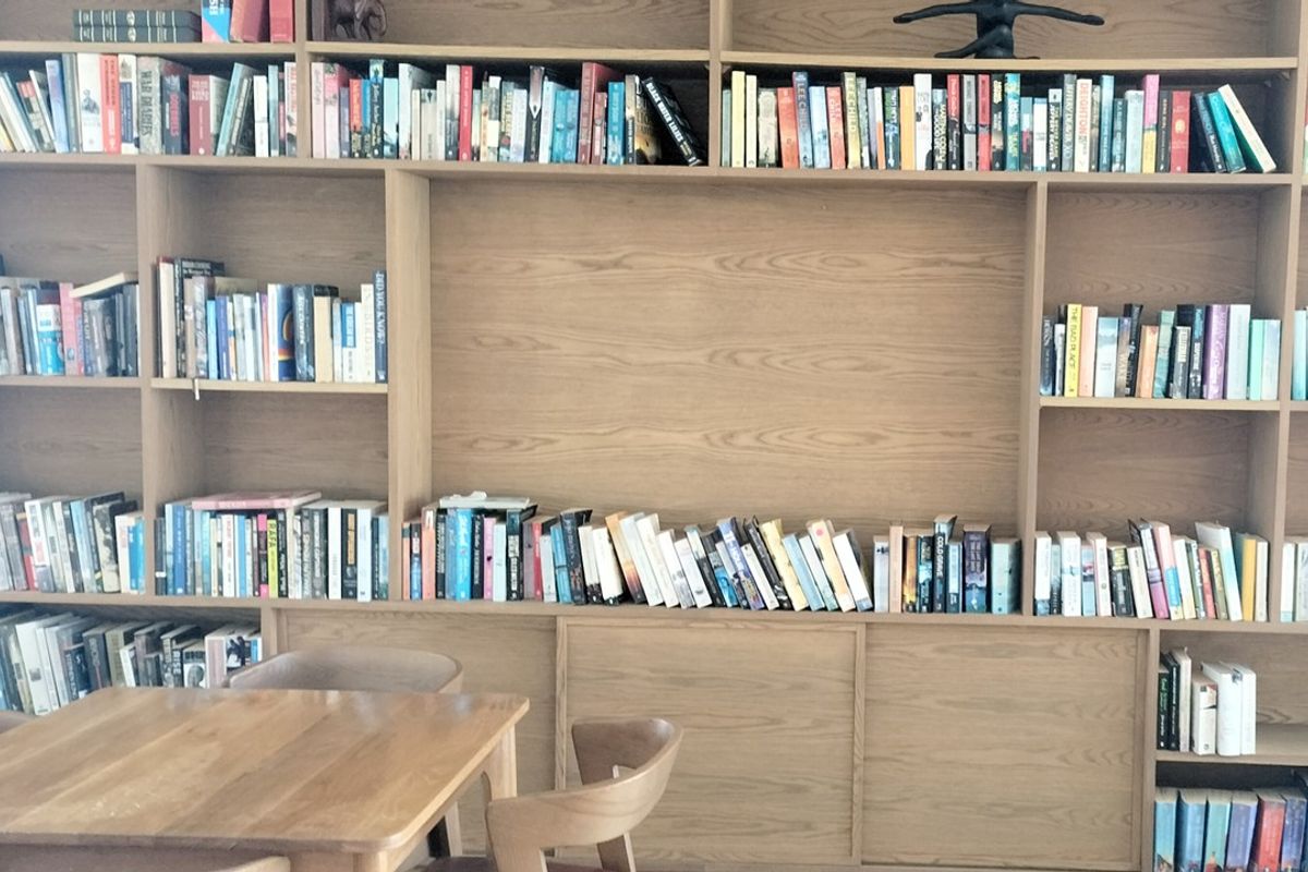 A large, custom-built wooden shelving unit providing extensive storage and display space, integrated into the living area.