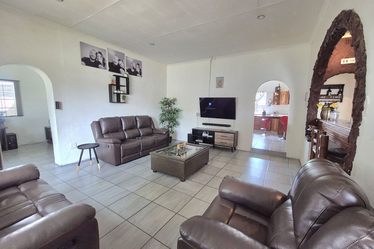 Spacious living room featuring tiled flooring, recessed lighting, and distinctive arched doorways leading to adjacent areas of the home.