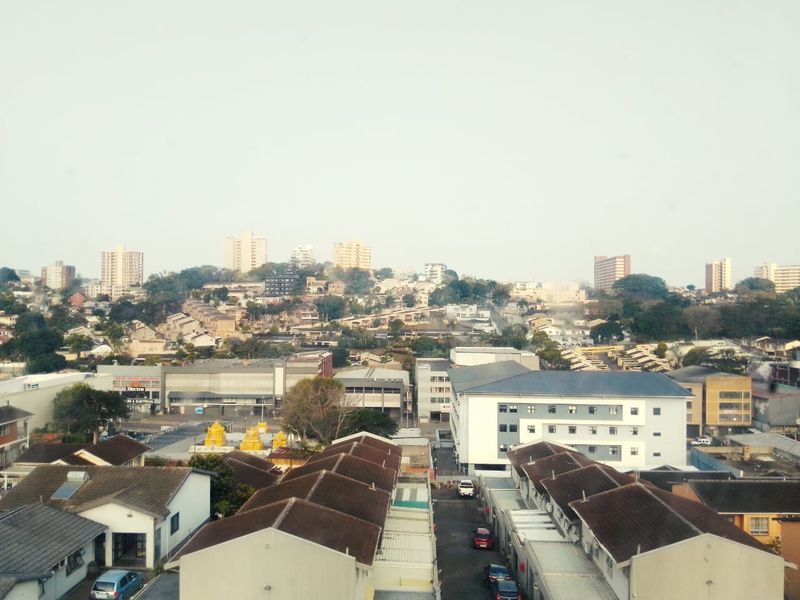 An elevated urban view overlooking a residential and commercial neighborhood with various building structures and rooftops.