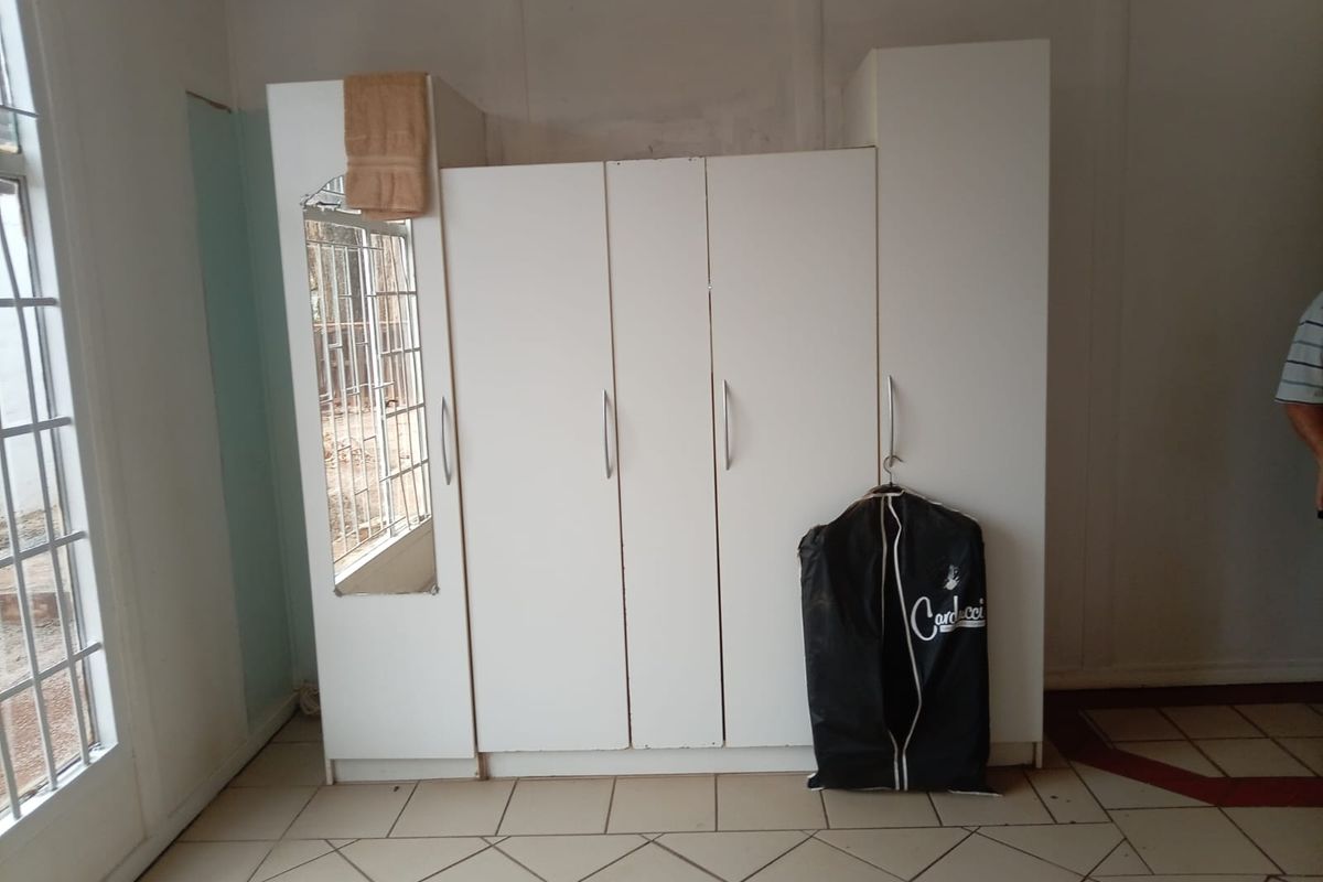 Bedroom featuring a built-in wardrobe, tiled flooring, and a glass panel door, requiring minor cosmetic repairs to the wall finishes.