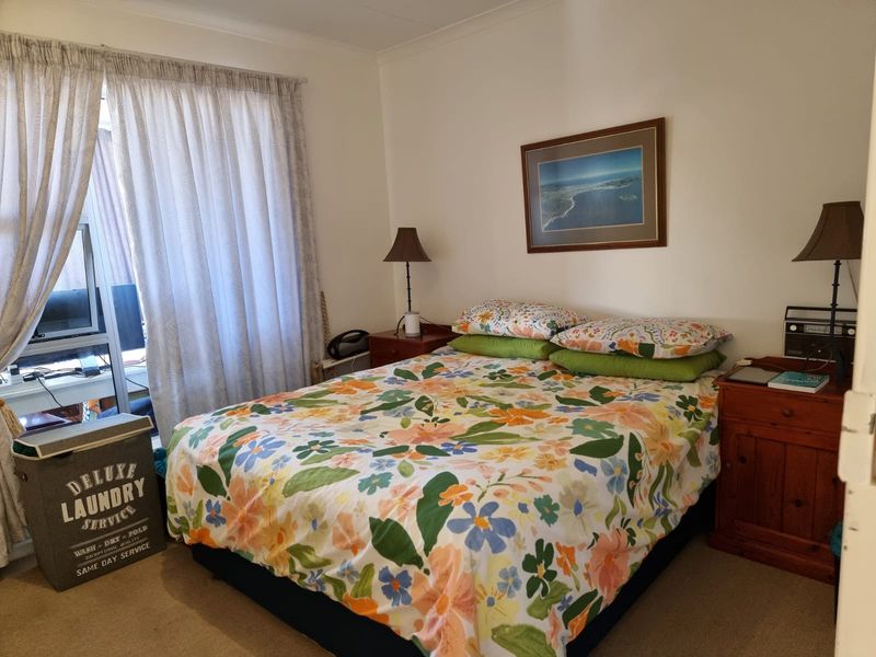 A functional bedroom featuring carpeted flooring and a sliding glass door providing access to the exterior.