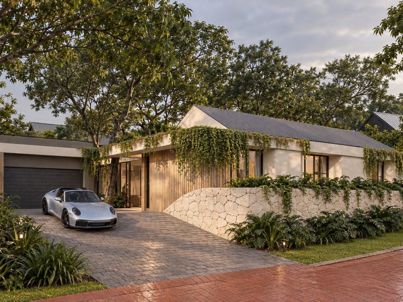 Modern single-story residence featuring a combination of stone and timber cladding, a paved driveway, and integrated garage, set within a lush landscaped environment.
