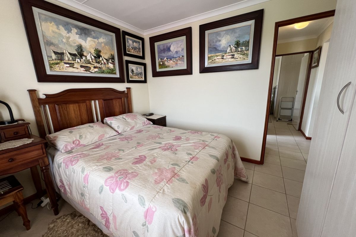 A bedroom featuring tiled flooring, cove cornicing, and a built-in wardrobe, with a doorway leading to an adjacent hallway.
