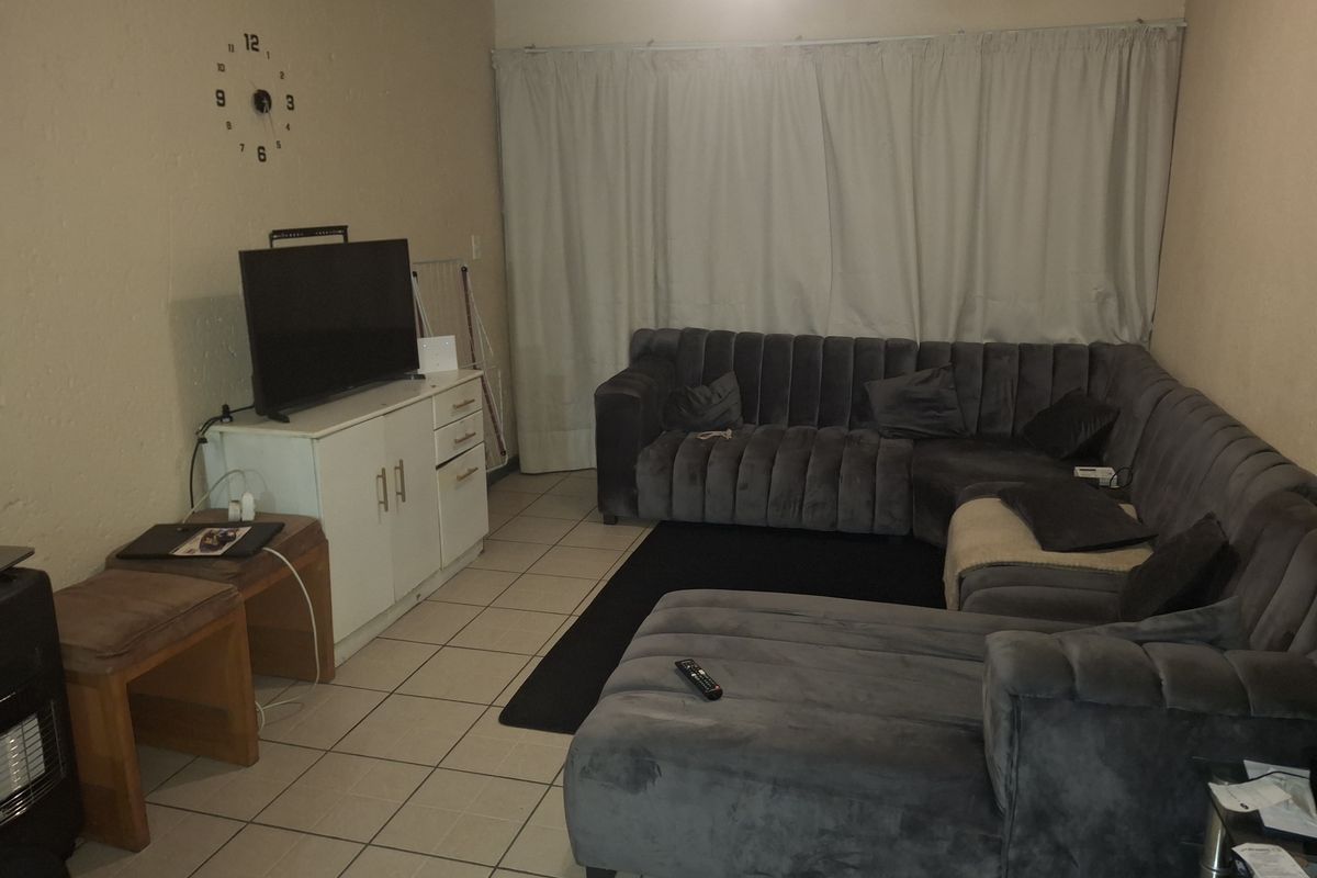 A living room featuring tiled flooring and neutral wall finishes, providing a functional space for relaxation.