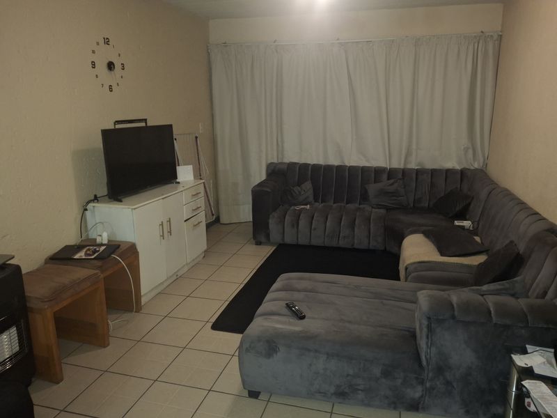 A living room featuring tiled flooring and neutral wall finishes, providing a functional space for relaxation.