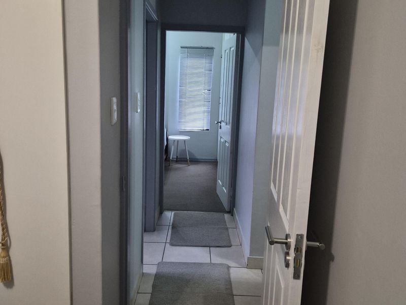 A functional hallway connecting interior spaces, featuring tiled flooring and standard internal doors.