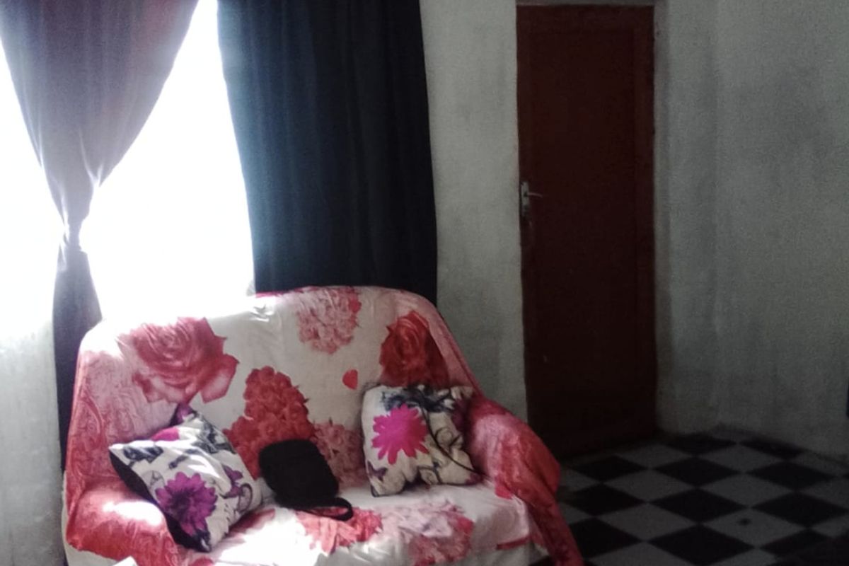 A living room area featuring patterned floor tiles and a standard internal door, requiring cosmetic updates to improve the overall aesthetic.