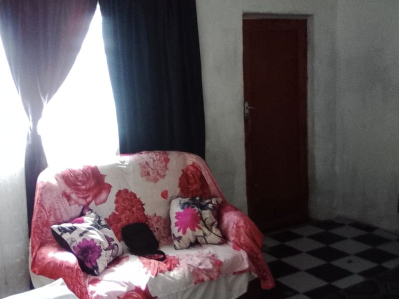 A living room area featuring patterned floor tiles and a standard internal door, requiring cosmetic updates to improve the overall aesthetic.