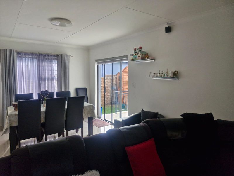 Open plan living and dining area featuring tiled flooring and a sliding glass door providing access to the rear garden.