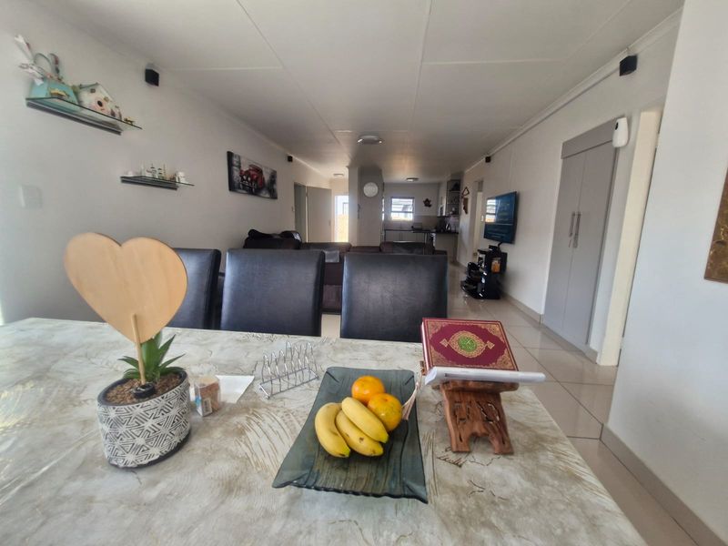 Open-plan living and dining area featuring tiled flooring and neutral wall finishes, providing a functional space for daily living.