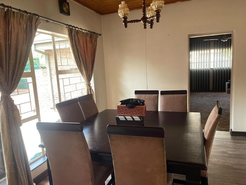 Dining room featuring laminate flooring, a timber ceiling, and a sliding glass door providing access to the exterior.
