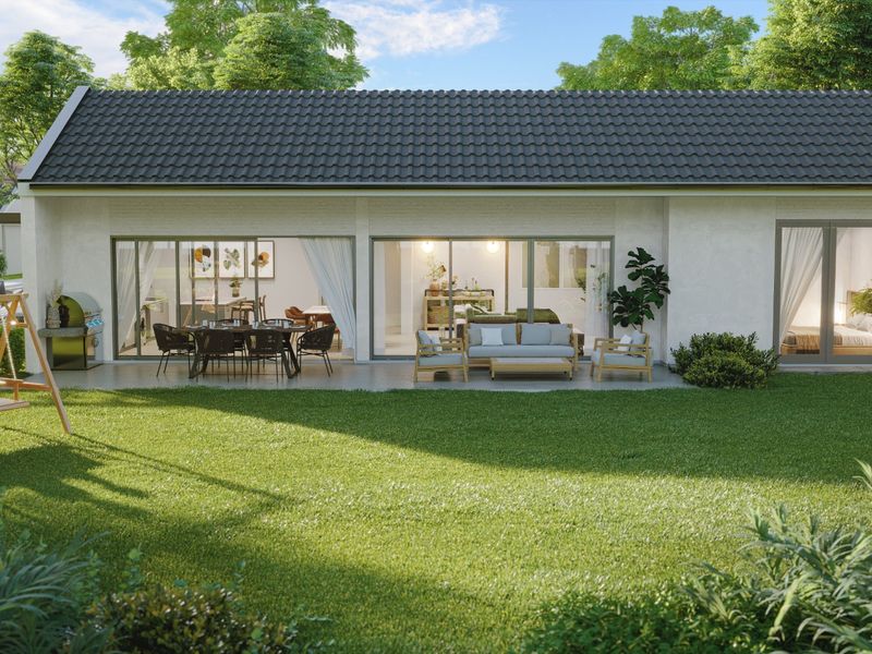 A rear view of a modern residential property featuring a spacious patio, large sliding glass doors, and a well-maintained garden.