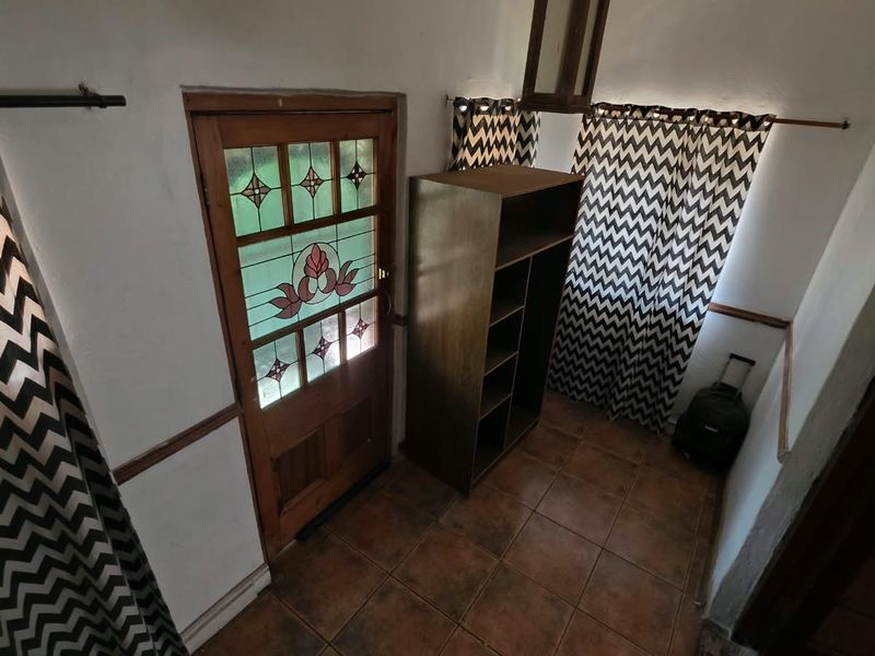 Entrance area featuring a classic stained glass timber door and durable ceramic floor tiles.
