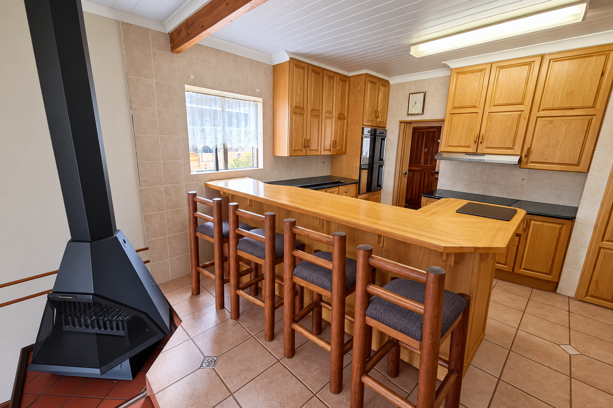 Kitchen featuring wooden cabinetry, a breakfast bar, tiled flooring, and a prominent freestanding fireplace, offering a functional layout with ample storage.