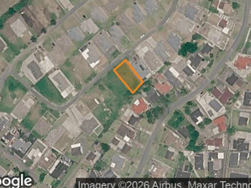 Aerial view of a vacant residential plot situated within an established suburban neighborhood.