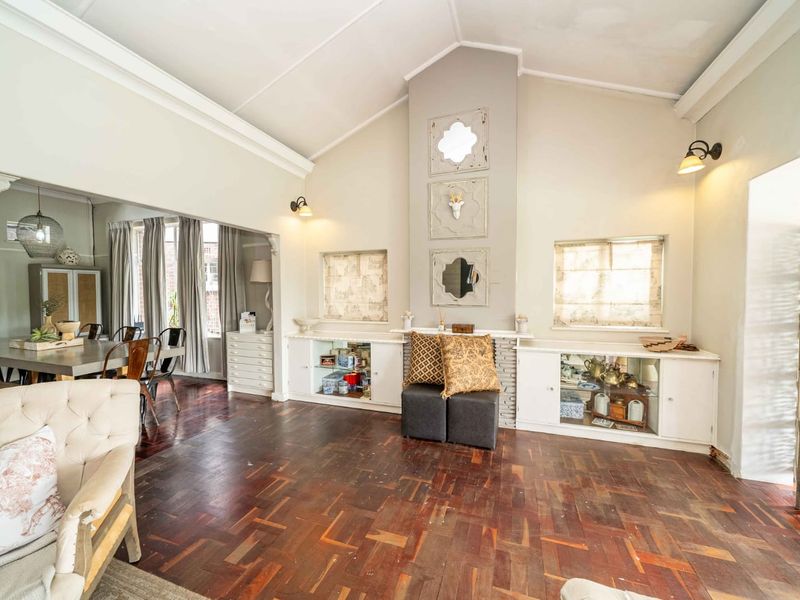 Spacious open-plan living area featuring vaulted ceilings, parquet flooring, and built-in cabinetry with a central fireplace feature.