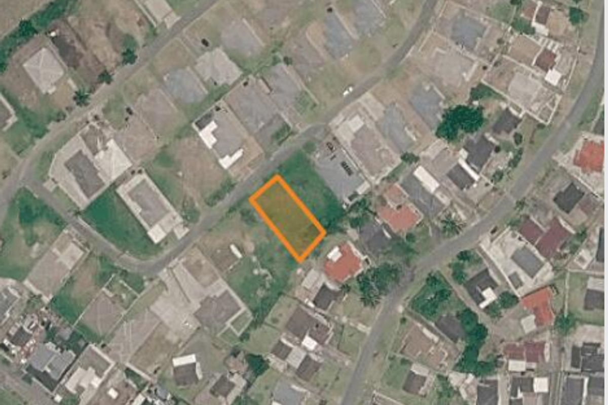 An aerial view of a vacant residential land plot situated within an established suburban neighborhood.