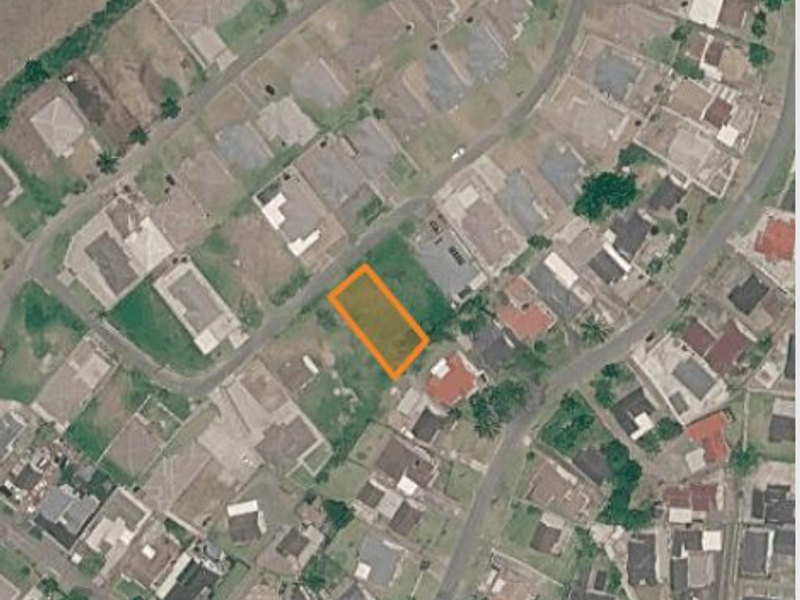 An aerial view of a vacant residential land plot situated within an established suburban neighborhood.