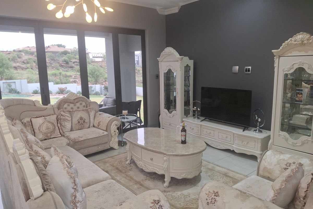 Spacious living room featuring large sliding glass doors that provide natural light and access to the outdoor area, complemented by modern ceiling lighting.