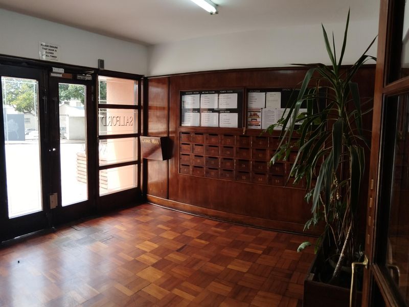Entrance foyer featuring classic parquet flooring, wood-paneled walls, and a built-in bank of mailboxes for residents.