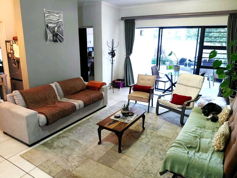 A spacious living room featuring large sliding glass doors that provide natural light and access to an outdoor patio area.
