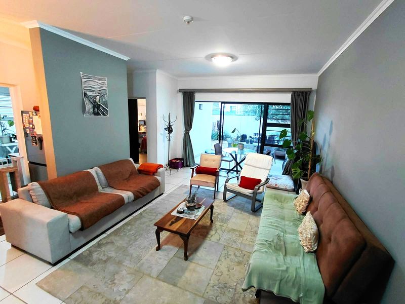 Spacious living room featuring tiled flooring and large sliding glass doors that provide access to an outdoor patio area.