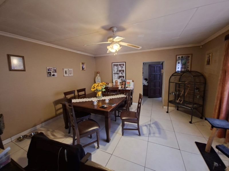 A dining room featuring tiled flooring and a central ceiling fan, providing a functional space for family meals.