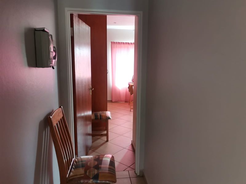 A functional hallway featuring tiled flooring and an integrated intercom system, providing access to adjacent living spaces.