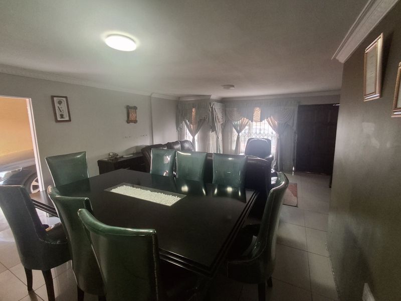 A dining room featuring tiled flooring and ceiling cornicing, providing a functional space for family meals and entertaining.
