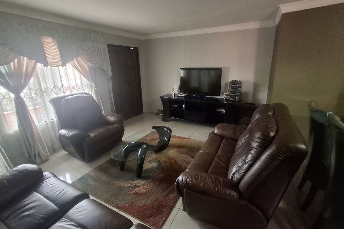 A living room featuring tiled flooring and decorative ceiling cornicing, providing a functional space for relaxation.