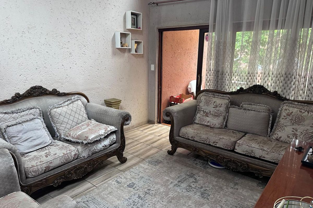 A living room featuring tiled flooring and a sliding glass door providing access to an outdoor area.