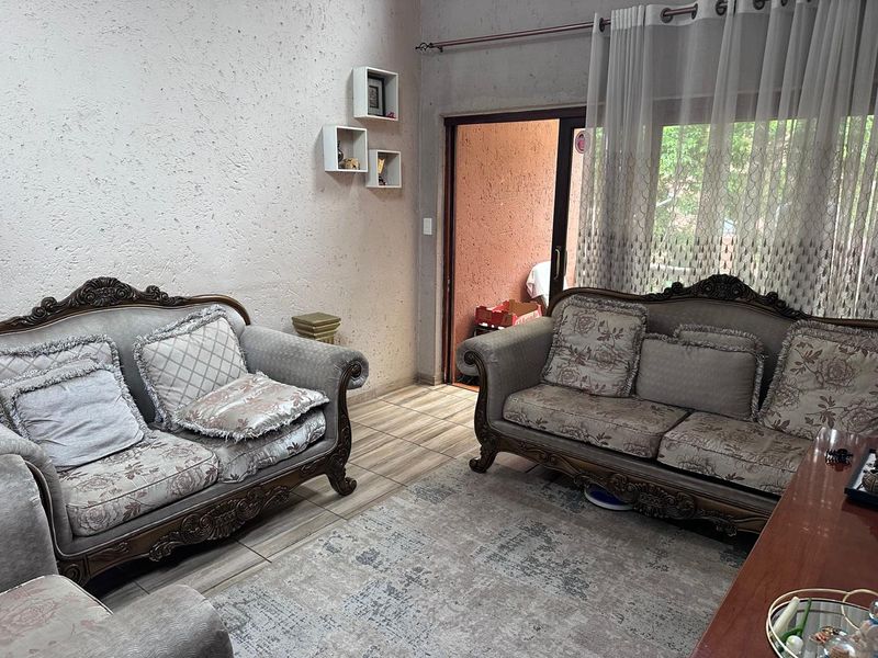 A living room featuring tiled flooring and a sliding glass door providing access to an outdoor area.