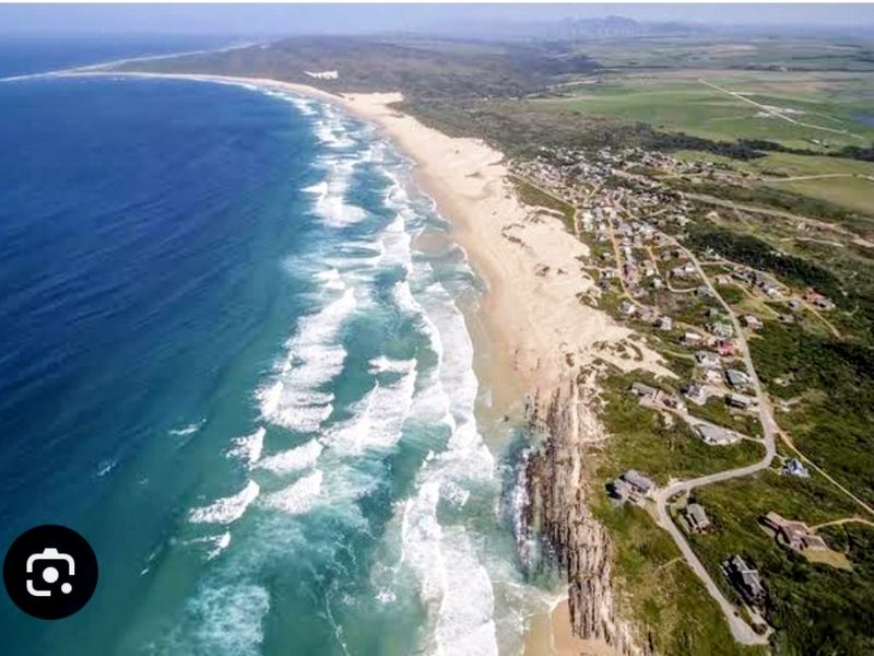An aerial view of the coastal residential area, showcasing the expansive beach, oceanfront, and surrounding landscape.