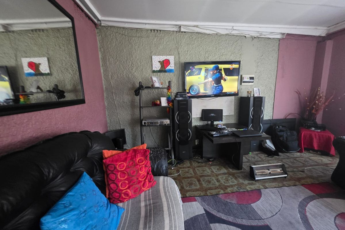 A living room featuring textured wall finishes and ceiling cornicing, currently requiring cosmetic updates to improve the overall aesthetic and finish quality.