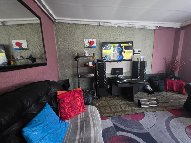 A living room featuring textured wall finishes and ceiling cornicing, currently requiring cosmetic updates to improve the overall aesthetic and finish quality.