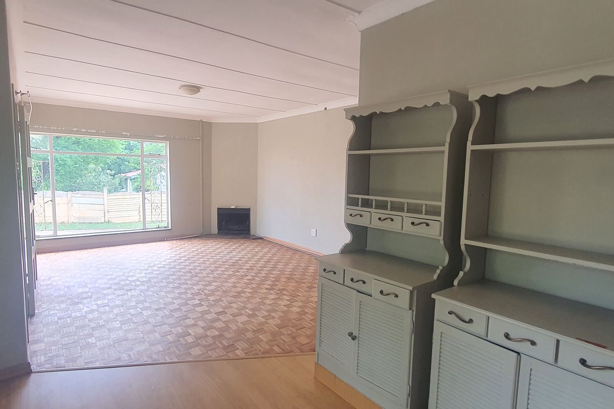 Spacious living area featuring parquet flooring, a built-in fireplace, and large windows that provide ample natural light.