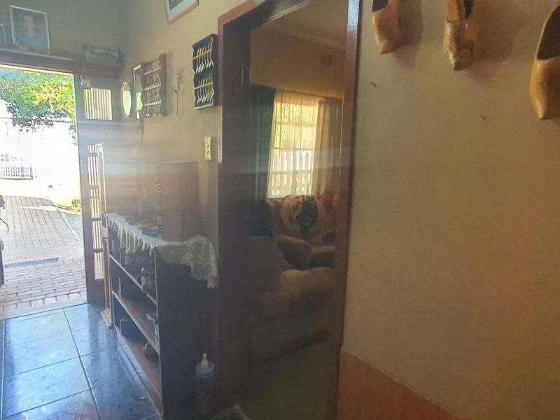 An entry hallway featuring tiled flooring and a security gate leading to the exterior, with a doorway providing access to the adjacent living area.