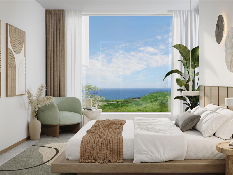A modern, well-appointed bedroom featuring timber wall paneling, recessed lighting, and a large picture window offering expansive coastal and landscape views.