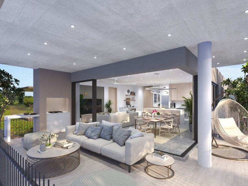 A spacious covered balcony featuring a built-in braai, recessed lighting, and seamless transition to the open-plan interior living and dining area.