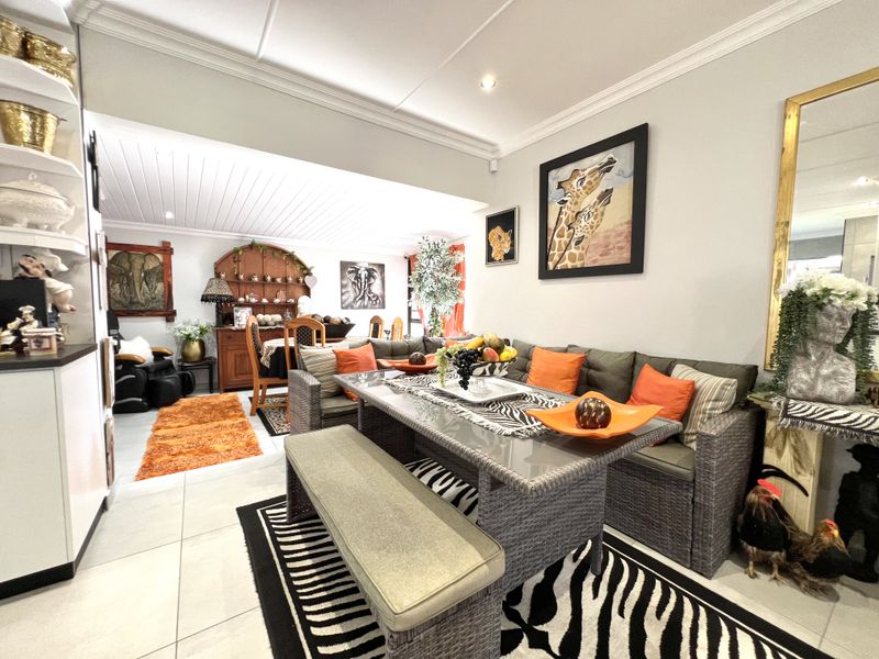 Spacious open-plan living and dining area featuring tiled flooring, recessed lighting, and crown molding, creating a bright and versatile space for family living.