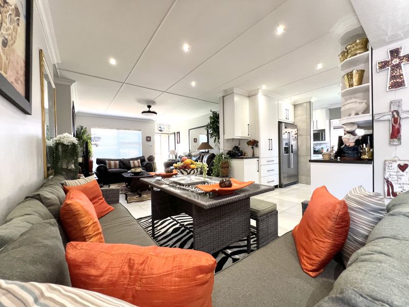 Spacious open-plan living and dining area featuring tiled floors, recessed lighting, and a modern kitchen with ample built-in cabinetry.