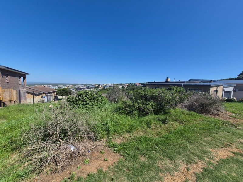 A wide-angle view of the vacant residential land, showcasing the surrounding neighborhood and natural landscape.