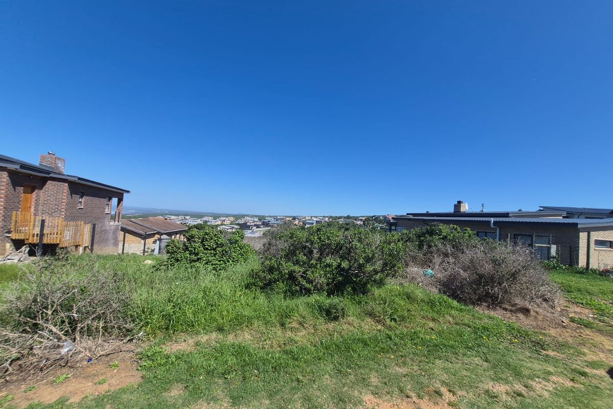 A wide-angle view of the residential land plot, showcasing the natural slope, existing vegetation, and surrounding neighborhood context.
