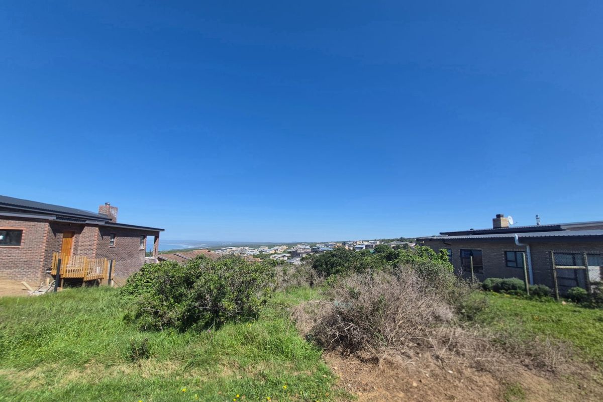A scenic view overlooking a residential neighborhood and coastal landscape, captured from the vacant land property.